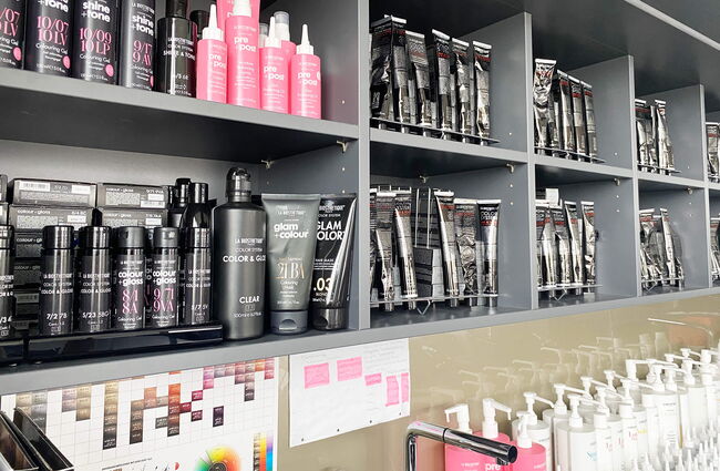 Regale Regale zeigen eine Vielzahl von Haarprodukten im Friseurraum von La Biosthétique, bereit zur Anwendung.