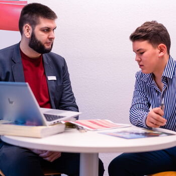 Zwei junge Männer sitzen an einem Tisch