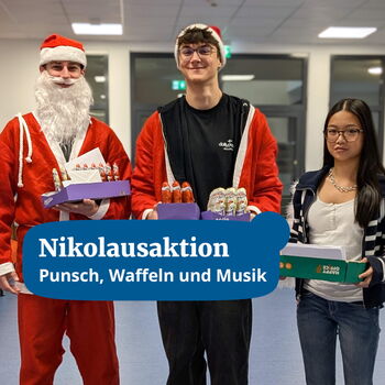 Drei Personen, darunter ein Nikolaus, präsentieren bei einer Nikolausaktion Tabletts mit Süßigkeiten in einer festlichen Umgebung.