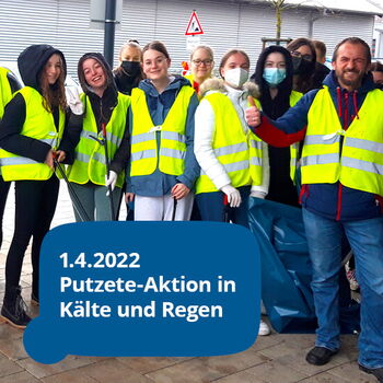 Eine Gruppe von Menschen in gelben Warnwesten bei einer Putzete-Aktion am 1.4.2022 trotz Kälte und Regen.