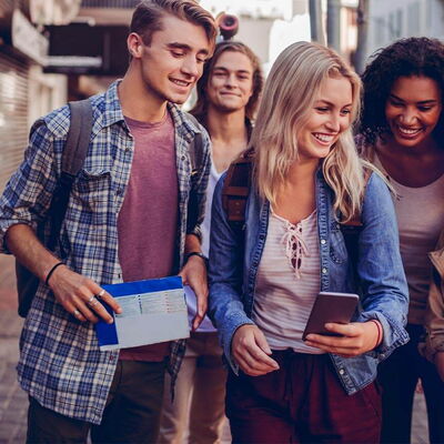 5 Schüler:innen lachen auf einer Strasse