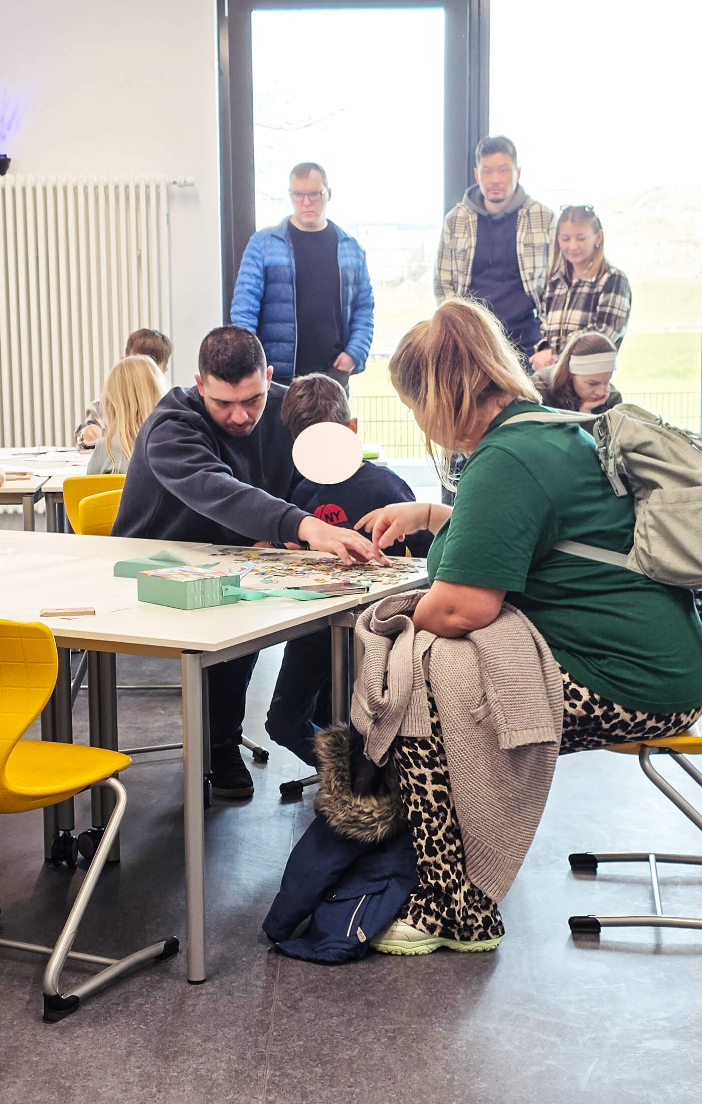Familienmitglieder erkunden gemeinsam Aktivitäten im Klassenraum der Grundschule beim Tag der offenen Tür.