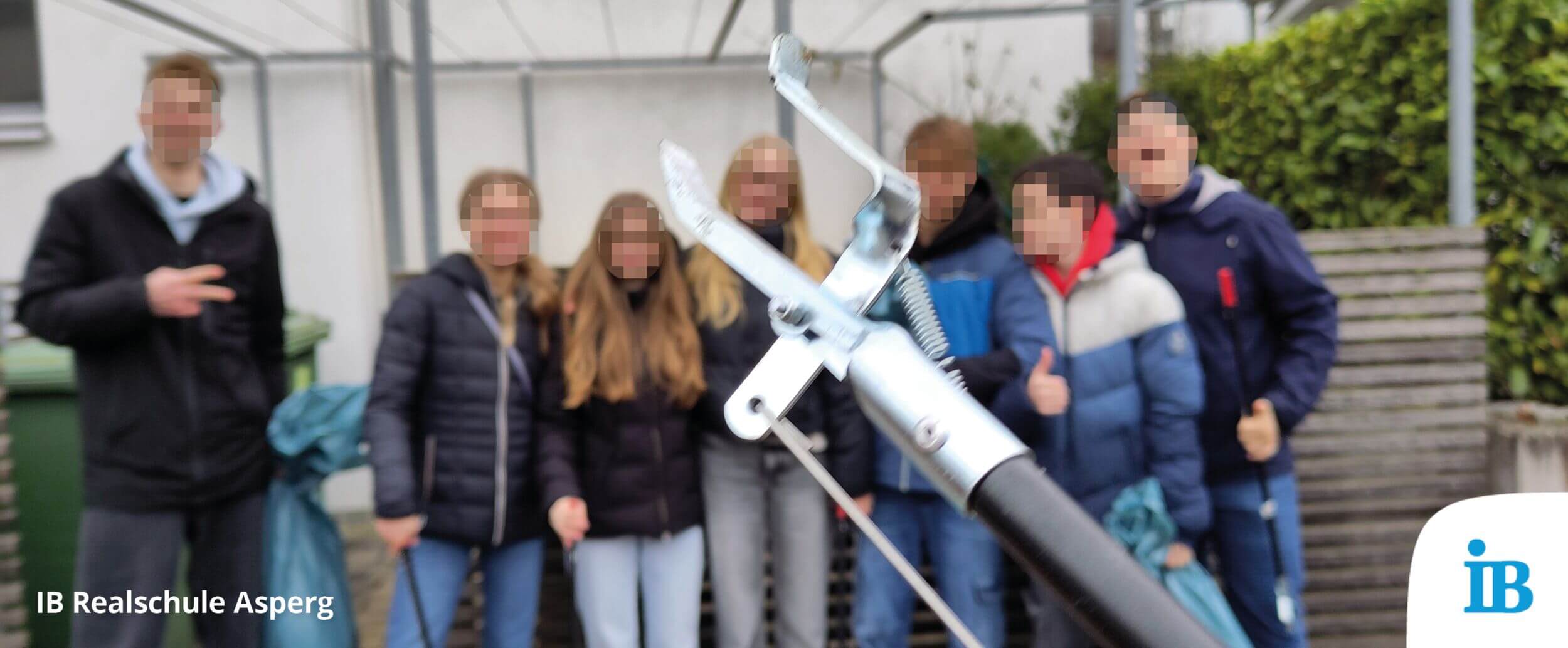 Schüler der Realschule Asperg posieren mit Müllzangen und Säcken während der Stadtputzete für ein Gruppenfoto.