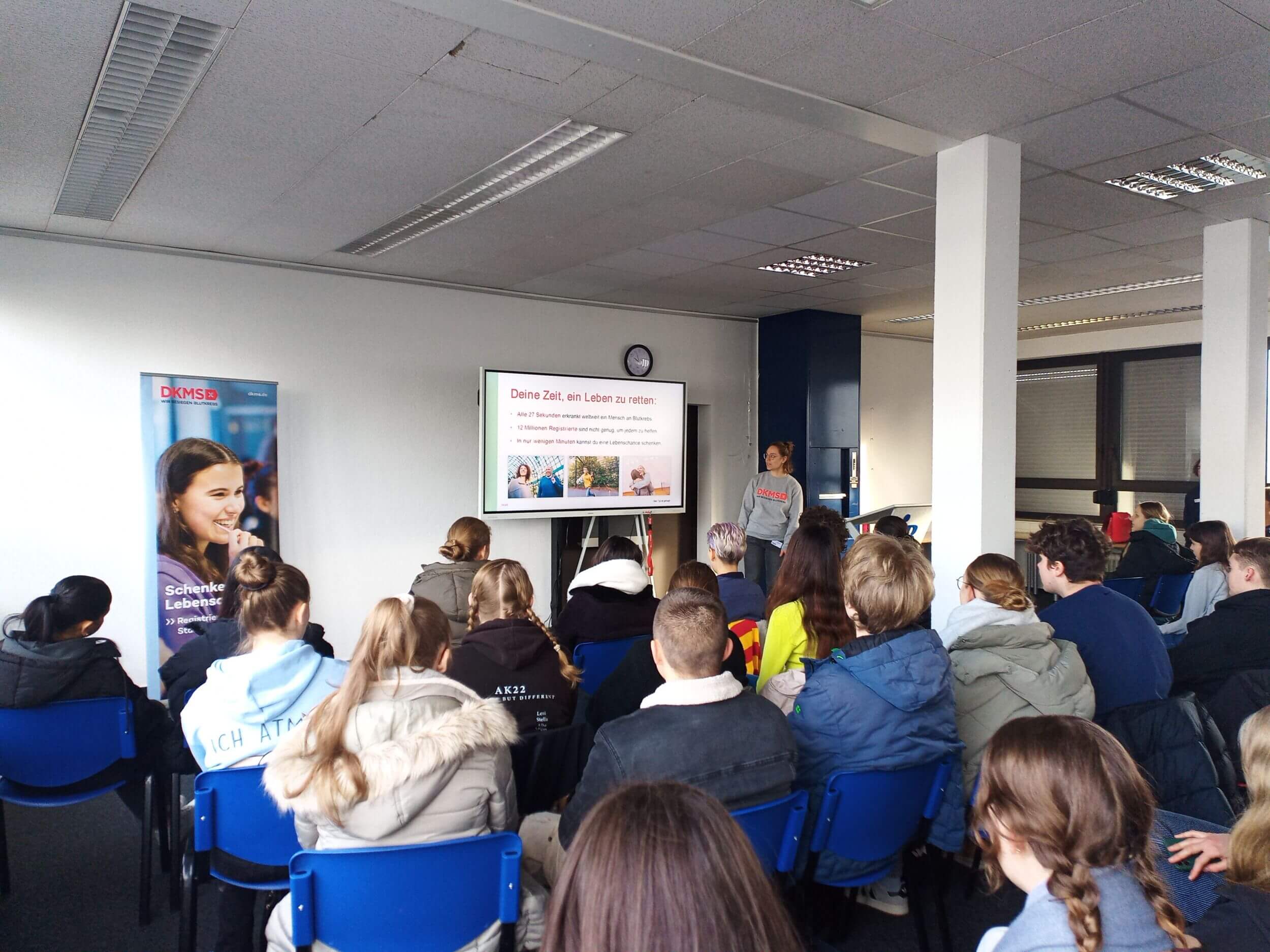 Eine Gruppe von Menschen sitzt in einem Klassenzimmer und hört einem Vortrag über das Retten von Leben zu.